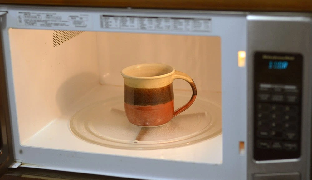 Cup with milk in microwave