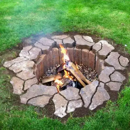 An in-ground stone fire pit in a natural setting