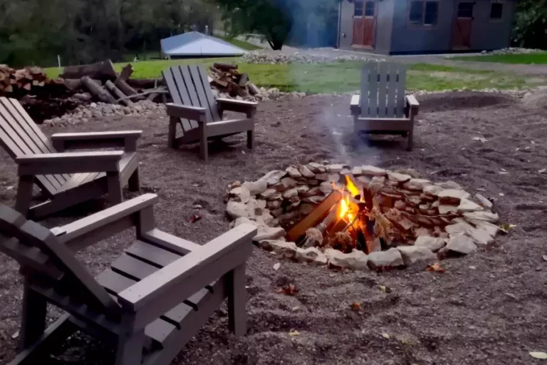 A rustic fire pit made from natural stone surrounded by seating