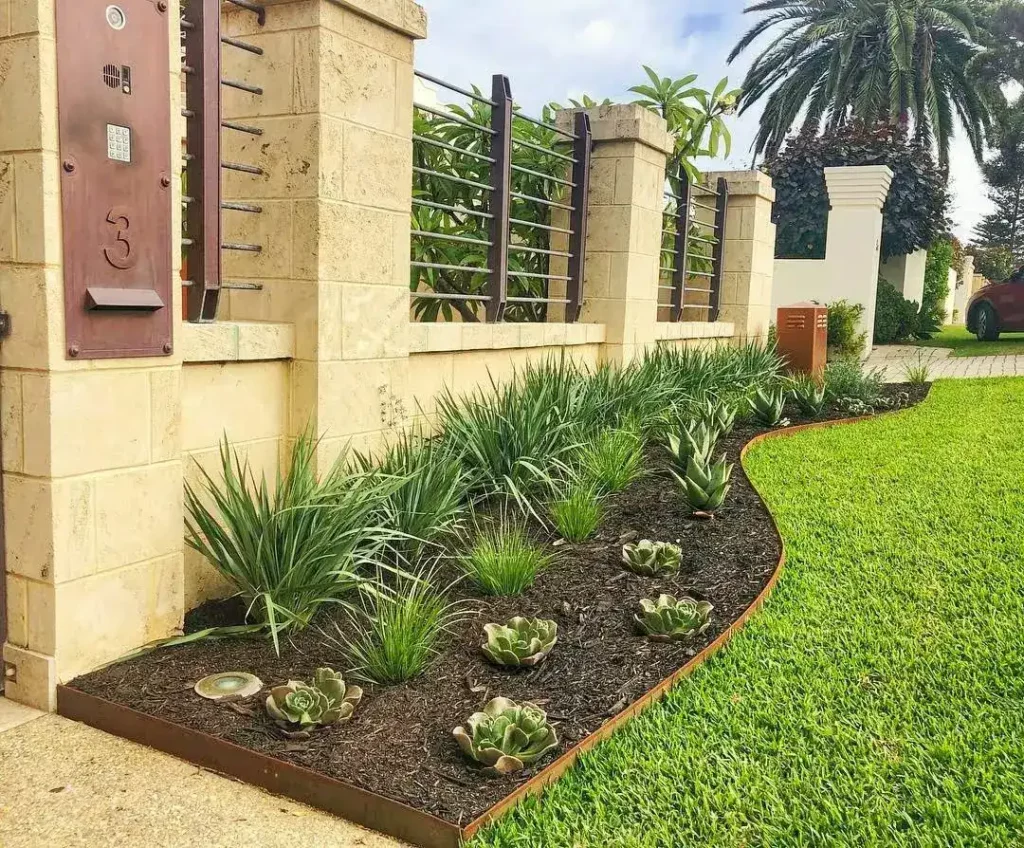 A garden border featuring weathered Corten steel edging with a rust-like appearance