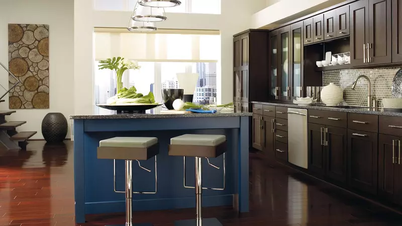 Dark cabinets contrasted with a cool blue backsplash in a stylish kitchen.