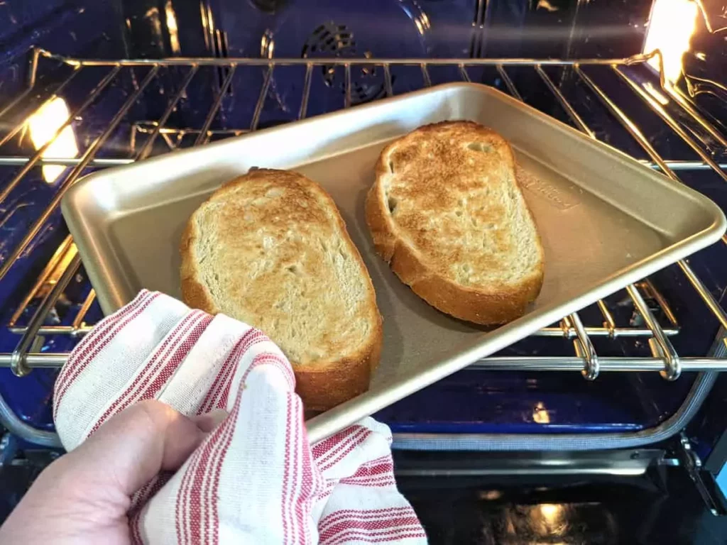 Two perfectly oven-toasted bread slices on a tray board.