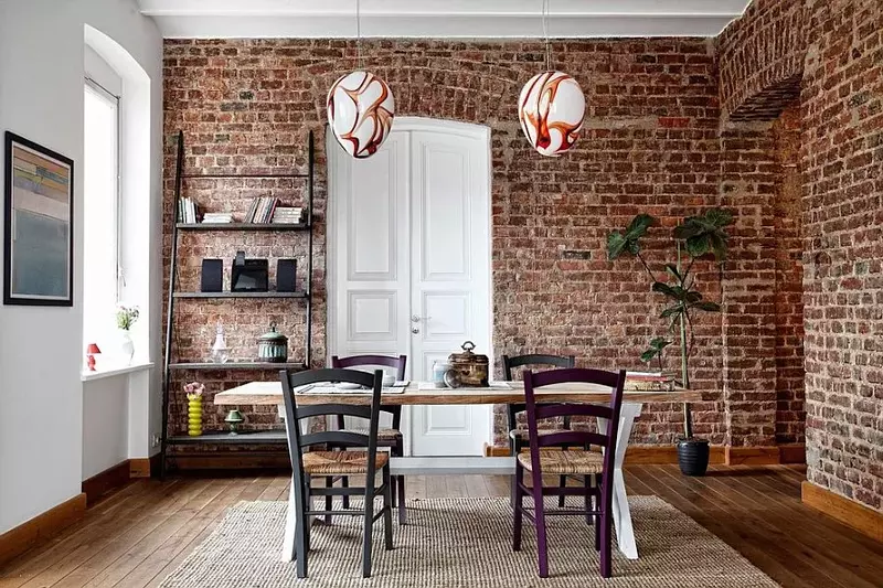 A cozy dining room with a rustic brick accent wall.