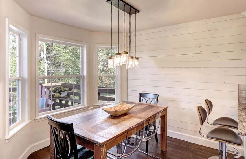 A cozy farmhouse dining room with a shiplap accent wall.