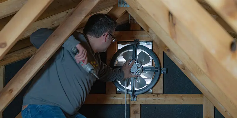 An attic with a gable mount attic fan installed