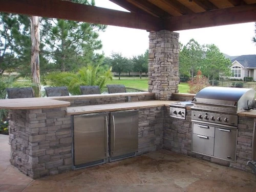 L-Shaped stone outdoor kitchen optimizing outdoor living space