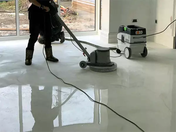 Person mopping a marble epoxy floor with a mild detergent to keep it clean and well-maintained