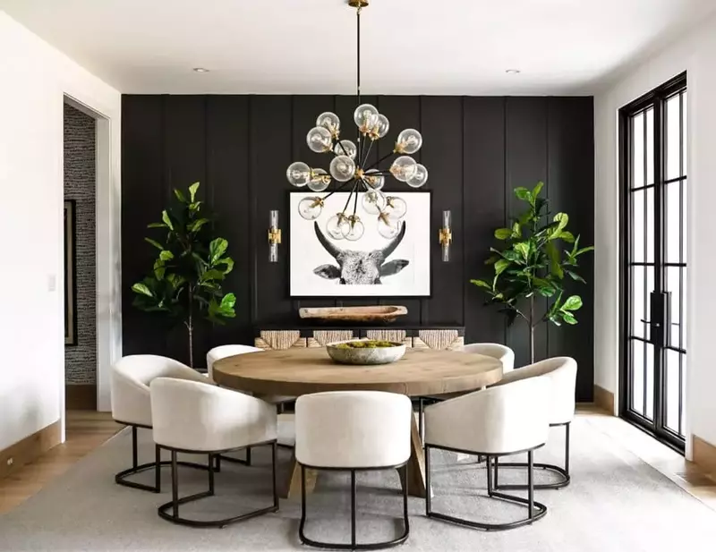 A beautifully decorated dining room showcasing a bold black accent wall.