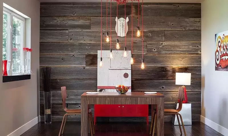 A rustic dining room with a reclaimed wood paneling accent wall.