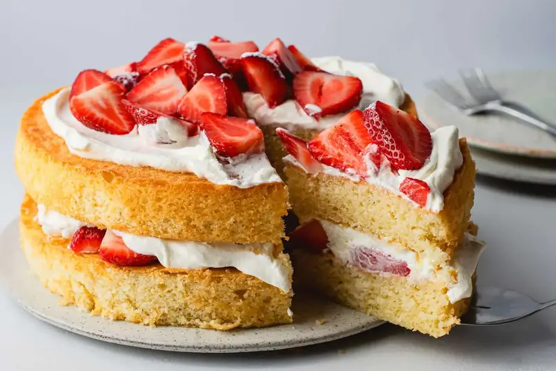 A tempting sponge cake topped with whipped cream and berries right from the fridge