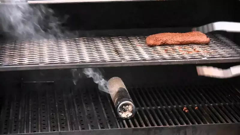 A stainless steel smoke tube for adding extra smoky flavor to BBQ dishes.
