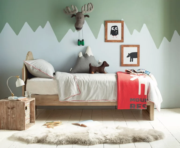 Toddler boy's room decorated in a nature theme with a treehouse bed and animal prints.