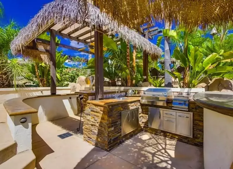 Tropical-style outdoor kitchen with local stones, bamboo accents, and lush greenery