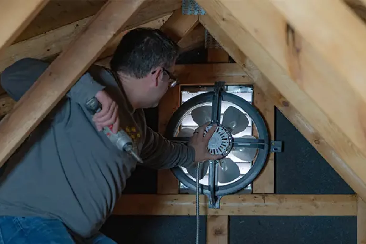 An attic with a gable mount attic fan installed